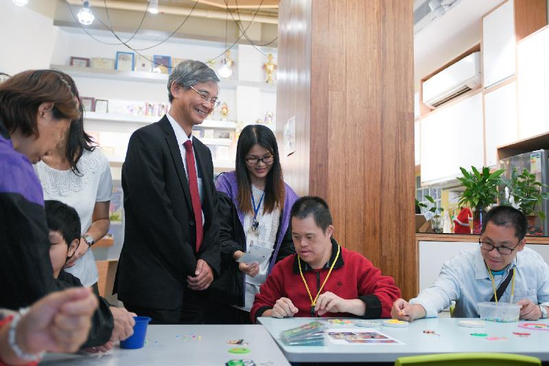 The Secretary for Labour and Welfare, Dr Law Chi-kwong, today (November 2) visited Central and Western District and called at Tung Wah Group of Hospitals Lok Kwan District Support Centre in Sai Ying Pun. Photo shows Dr Law (fourth right) watching persons with disabilities playing with beads for training eye-hand co-ordination.