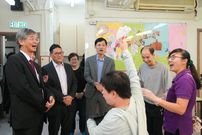 The Secretary for Labour and Welfare, Dr Law Chi-kwong, today (November 2) visited Central and Western District and called at Parkside Residence and Parkside Integrated Service Team operated by St James' Settlement Rehabilitation Services in Sai Ying Pun. Photo shows Dr Law (first left) and the Chairman of the Central and Western District Council, Mr Yip Wing-shing (second left), watching a person with intellectual disability performing.