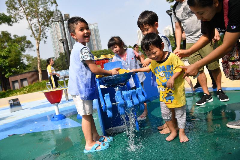 The inclusive playground in Tuen Mun Park will be opened for public use on December 3. It is the first barrier-free play space for children in Hong Kong incorporating two natural elements, water and sand, in its design. Photo shows children playing at the water cascade platform in the Flower Dew Plaza.