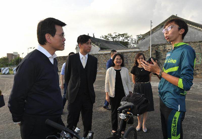 The Secretary for Commerce and Economic Development, Mr Edward Yau (first left), exchanges views with young tour guides of the Tung Wah Group of Hospitals BiciLine Cycling Eco-Tourism Social Enterprise during his visit to Yuen Long District today (December 3).