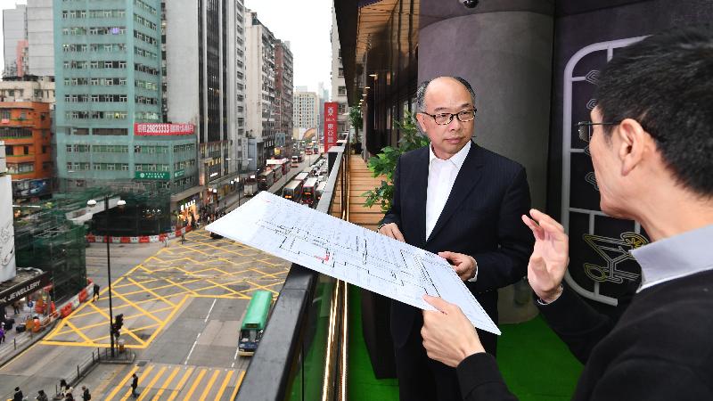 The Secretary for Transport and Housing, Mr Frank Chan Fan, visited Yau Tsim Mong District this afternoon (December 7). Picture shows Mr Chan (left) viewing the pedestrian footbridge at Mong Kok Road and being updated by a Highways Department officer on the works progress of the extension of the footbridge system straddling Nathan Road.