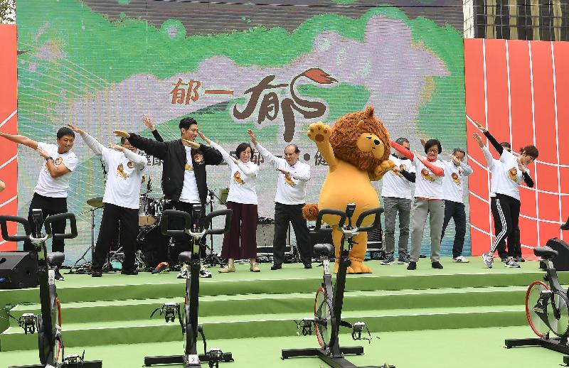 政务司司长张建宗（左五）今日（十二月八日）在「健康香港2025 | 郁一郁・健康啲」宣传运动启动礼上，与食物及卫生局局长陈肇始教授（左四）、卫生署署长陈汉仪医生（右四）及其他主礼嘉宾和为宣传运动而设的吉祥物「匿狮Lion」跟着宣传主题曲跳舞，与在场的参加者分享做运动的乐趣。
