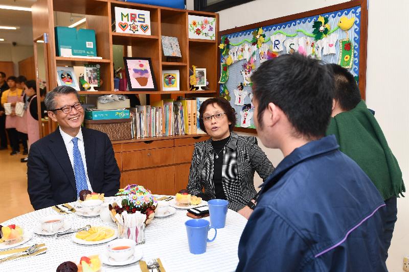 財政司司長陳茂波今日（十二月十二日）下午到訪九龍城區。圖示陳茂波（左一）在天保民學校校長陳雅麗（左二）陪同下與學生交流，了解他們的學習生活。