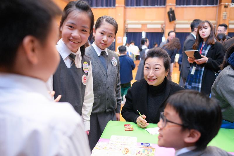 The Secretary for Justice, Ms Teresa Cheng, SC, visits SKH Tak Tin Lee Shiu Keung Primary School in Lam Tin today (December 13). Photo shows Ms Cheng (third left) chatting with students participating in creative English teaching project "SimCity".