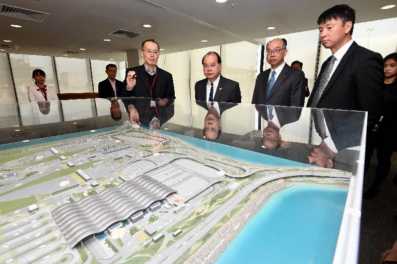The Chief Secretary for Administration, Mr Matthew Cheung Kin-chung (fourth left), accompanied by the Secretary for Transport and Housing, Mr Frank Chan Fan (fifth left), today (December 19) views a model of the Hong Kong Port of the Hong Kong-Zhuhai-Macao Bridge and receives a briefing on the facilities at the port by the Project Manager/Major Works (Special Duties) of the Highways Department, Mr Raymond Kong (third left). 