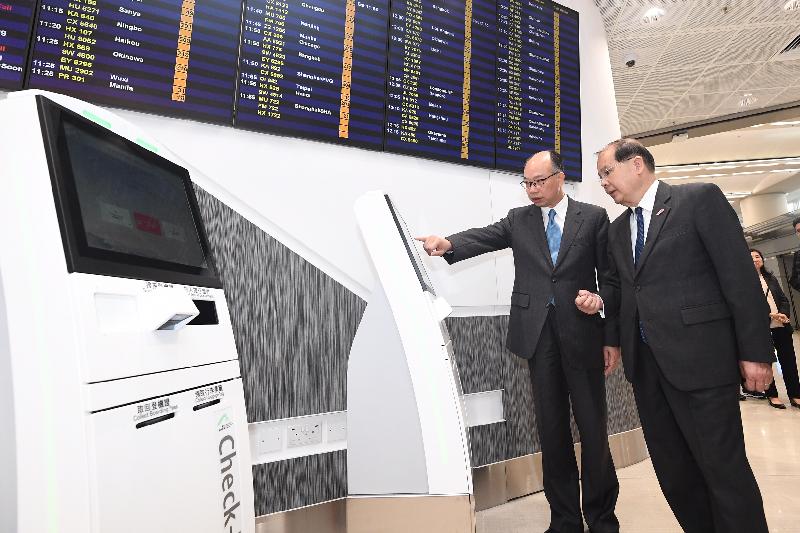 The Chief Secretary for Administration, Mr Matthew Cheung Kin-chung (right), today (December 19) visits the Hong Kong Port of the Hong Kong-Zhuhai-Macao Bridge and receives a briefing from the Secretary for Transport and Housing, Mr Frank Chan Fan, on the operation of the smart check-in kiosks of Hong Kong International Airport at the Arrival Hall of the Passenger Clearance Building. 