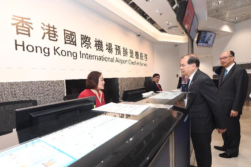 The Chief Secretary for Administration, Mr Matthew Cheung Kin-chung, today (December 19) visited the Hong Kong Port of the Hong Kong-Zhuhai-Macao Bridge. Photo shows Mr Cheung (second right), accompanied by the Secretary for Transport and Housing, Mr Frank Chan Fan (first right), exchanging views with a staff member at the check-in service counters of Hong Kong International Airport at the Arrival Hall of the Passenger Clearance Building.