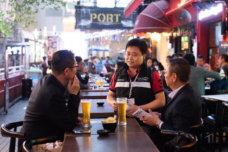 The Department of Health's Tobacco and Alcohol Control Office today (December 21) said that it will strengthen inspections and enforcement actions during the Christmas and New Year period against the illegal sale of alcohol to minors and smoking offences in pubs and bars. Photo shows a Tobacco and Alcohol Control Inspector distributing leaflets to customers in pubs in Knutsford Terrace in Tsim Sha Tsui to remind them to comply with the law and not to smoke in statutory no-smoking areas.
