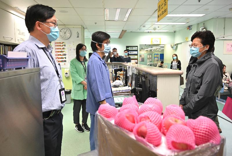 The Chief Executive, Mrs Carrie Lam (right), this morning (January 1) visited Tuen Mun Hospital to learn about various measures that the Hospital Authority had put in place during the winter surge of influenza and extend New Year greetings to the healthcare workers and patients. Photo shows Mrs Lam chatting with healthcare workers of the Accident and Emergency Department and bringing apples to them to express her gratitude for their dedication in providing quality services to the patients.