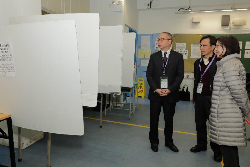 The Secretary for Home Affairs, Mr Lau Kong-wah, visited the polling station at Ta Ku Ling Ling Ying Public School in North District today (January 6). Photo shows Mr Lau (left), the Director of Home Affairs, Miss Janice Tse (right) and the District Officer (North), Mr Chong Wing-wun (centre) observing the operation of the polling station.