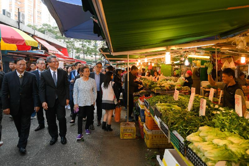 The Financial Secretary, Mr Paul Chan (front row, second left), accompanied by the Chairman of the Eastern District Council, Mr Wong Kin-pan (front row, first left), and the District Officer (Eastern), Mr Simon Chan (second row, first left), visits hawker stalls in Eastern District this afternoon (January 11) and exchanges views with business operators.
