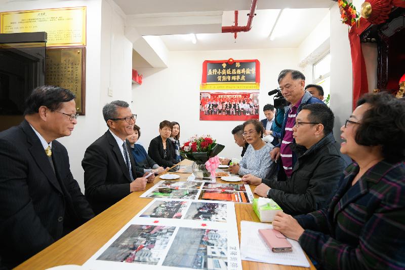The Financial Secretary, Mr Paul Chan (second left), accompanied by the Chairman of the Eastern District Council, Mr Wong Kin-pan (first left), visits the Hong Kong Vegetable Food and Grocery Hawkers Welfare and Fraternity Association Limited in Eastern District this afternoon (January 11) and meets with representatives to learn more about the hawkers' business environment.