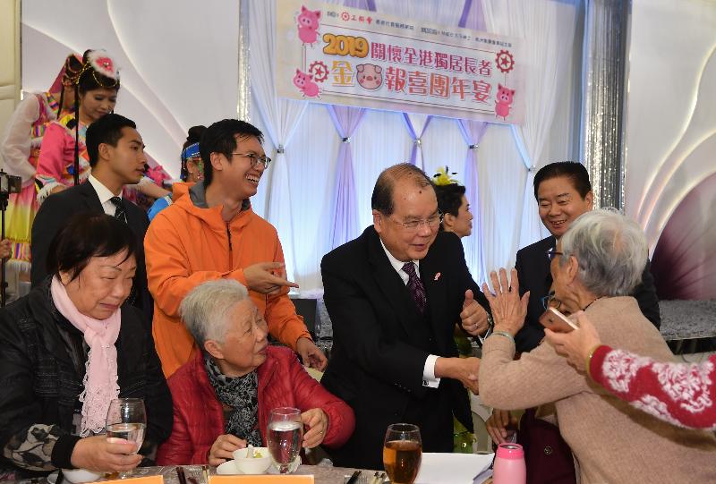 署理行政长官张建宗今日（一月二十一日）傍晚出席香港工会联合会举办的「关怀全港独居长者　金猪报喜团年宴」。图示张建宗（右二）向长者问好，祝愿他们在新的一年健康愉快。