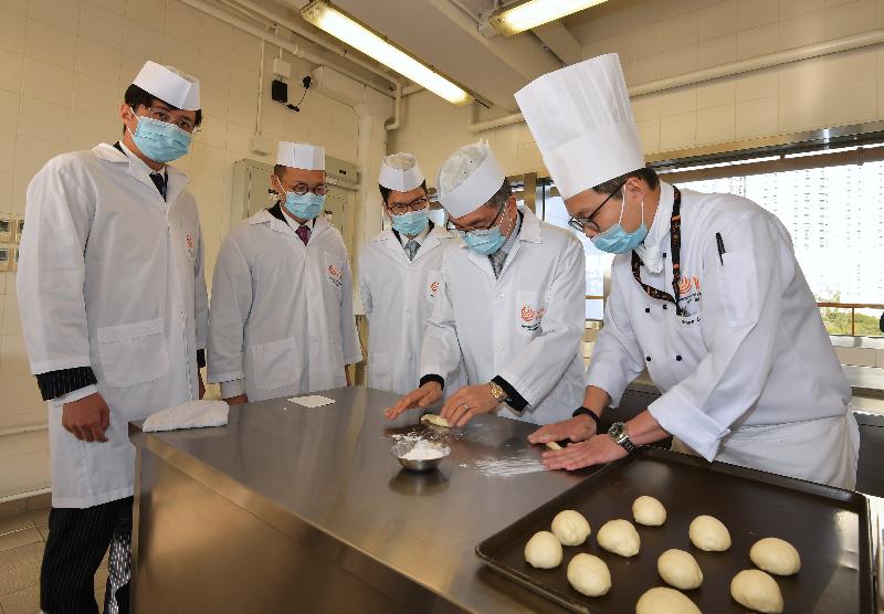The Secretary for Financial Services and the Treasury, Mr James Lau (second right), tours the bakery kitchen at the Hotel and Tourism Institute (Tin Shui Wai) of the Vocational Training Council today (January 24) and tries bread making. Also participating is the Under Secretary for Financial Services and the Treasury, Mr Joseph Chan (centre). 
