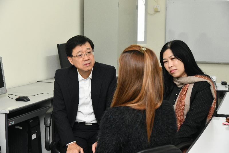 During his visit to Sha Tin this afternoon (January 25), the Secretary for Security, Mr John Lee (left), listens to a volunteer who has received services of the Adult Female Rehabilitation Centre of the Society for the Aid and Rehabilitation of Drug Abusers and successfully quit drugs.