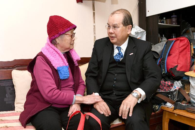 The Chief Secretary for Administration, Mr Matthew Cheung Kin-chung, today (January 28) visited elderly families at Yue Kwong Chuen in Aberdeen. Photo shows Mr Cheung (right) chatting with a resident there.