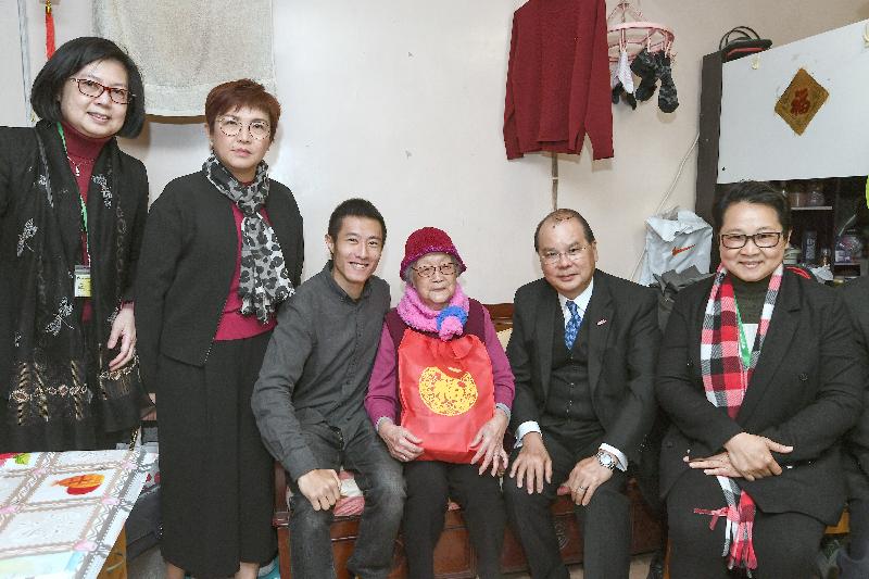 The Chief Secretary for Administration, Mr Matthew Cheung Kin-chung, today (January 28) visited elderly families at Yue Kwong Chuen in Aberdeen. Photo shows Mr Cheung (second right) giving warm clothing and health products as gifts to an elderly person.