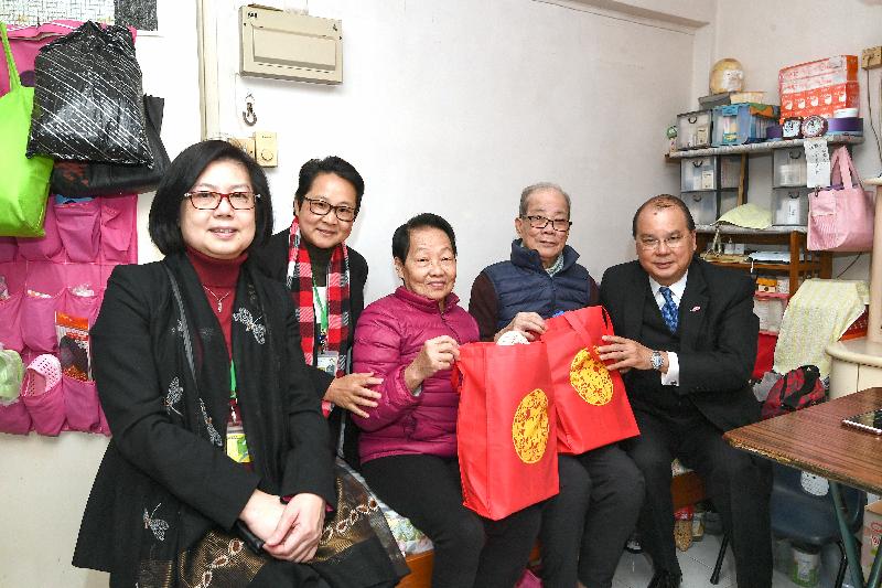 The Chief Secretary for Administration, Mr Matthew Cheung Kin-chung, today (January 28) visited elderly families at Yue Kwong Chuen in Aberdeen. Photo shows Mr Cheung (first right) giving warm clothing and health products as gifts to the elderly people.