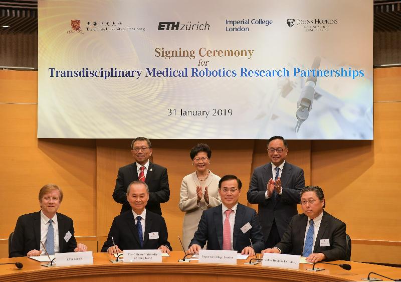 The Chief Executive, Mrs Carrie Lam, attended the Signing Ceremony for Transdisciplinary Medical Robotics Research Partnerships between the Chinese University of Hong Kong (CUHK) and overseas institutes today (January 31). Photo shows Mrs Lam (back row, centre); the Secretary for Innovation and Technology, Mr Nicholas W Yang (back row, right); and the Vice-Chancellor and President of CUHK, Professor Rocky Tuan (back row, left), witnessing the signing of a Memorandum of Understanding by representatives of CUHK, ETH Zurich, the Imperial College London and Johns Hopkins University. 