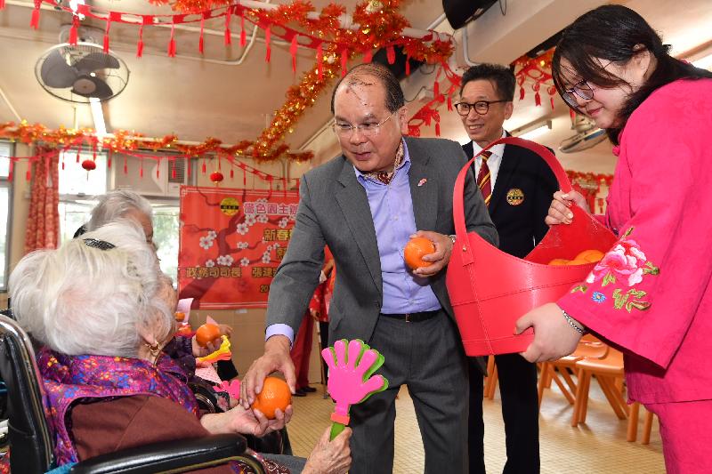 政务司司长张建宗今早（二月五日）到访大埔一所护理安老院，向长者送上节日祝贺。图示张建宗（右三）向长者送上甜柑。