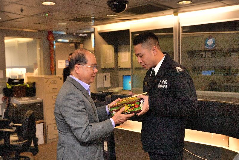 The Chief Secretary for Administration, Mr Matthew Cheung Kin-chung (left), visits Lok Ma Chau Boundary Control Point this morning (February 5). Photo shows Mr Cheung presenting candies to an officer on duty to extend his warmest gratitude to all officers on duty for holding fast to their posts and serving the public with excellence during the Lunar New Year.