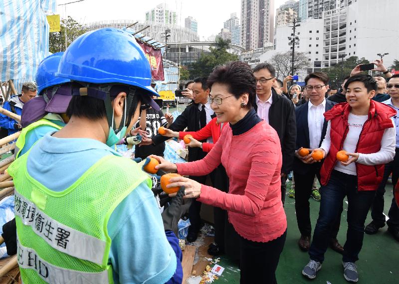 行政长官林郑月娥今日（二月五日）大年初一早上，到维多利亚公园视察年宵市场清洁工作。图示林郑月娥（右一）向当值的食物环境卫生署同事送上甜柑。