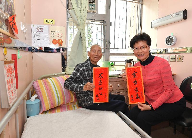 The Chief Executive, Mrs Carrie Lam , visits 98-year-old Uncle Fook at a home for the elderly in Tsz Wan Shan this morning (February 5). Mrs Lam (right) is being presented spring couplets prepared by Uncle Fook himself.