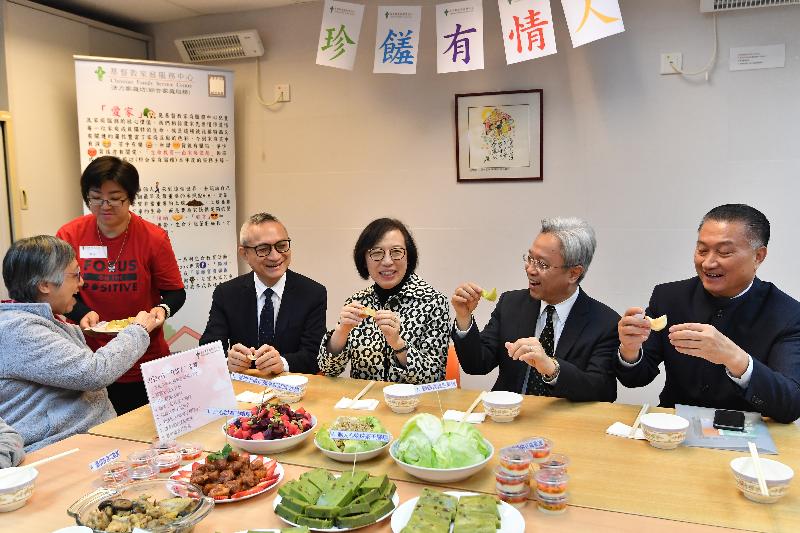 The Secretary for Civil Service, Mr Joshua Law, and the Secretary for Food and Health, Professor Sophia Chan, today (February 14) visited the Christian Family Service Centre Jockey Club Building in Kwun Tong District. Photo shows Mr Law (second right) and Professor Chan (third right) listening to local residents introducing dishes they prepared for their families.