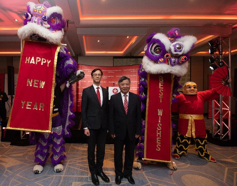 香港驻三藩市经济贸易办事处处长蒋志豪（左）和中华人民共和国驻休斯敦总领事李强民（右）于二月十一日（休士顿时间）在休士顿举行的新春酒会与舞狮表演团体合照。