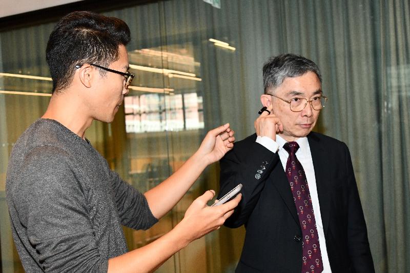 The Secretary for Financial Services and the Treasury, Mr James Lau (right), is briefed on a product while touring the Mills Fabrica, an incubator that boosts the growth of innovative start-ups, during his district visit to Tsuen Wan today (February 15).