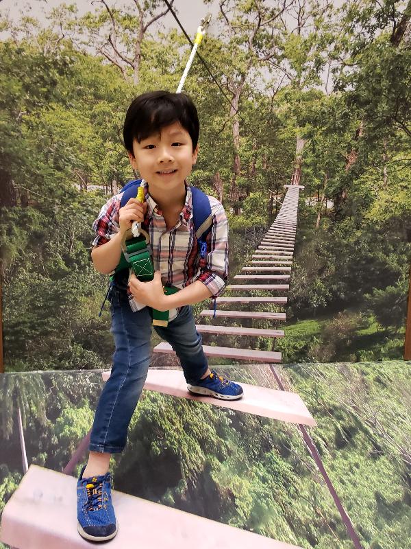 The Government launched a public consultation on February 16 to seek public views on the proposals for "Enhancing the Recreation and Education Potential of Country Parks and Special Areas in Hong Kong". Photo shows a boy at the interactive Tree Top Adventure 3D photo booth at the exhibition.