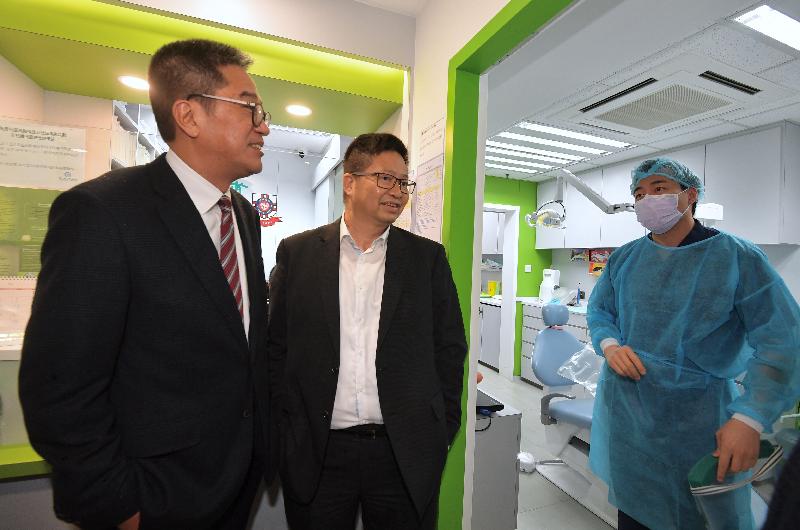The Secretary for Development, Mr Michael Wong (left), visited the facilities of the Pok Oi Hospital Dental Service Support Base in Cheung Ching Community Centre during his visit to Kwai Tsing District today (February 18). Photo shows Mr Wong chatting with a dentist at the Support Base. Looking on is the Chairman of the Kwai Tsing District Council, Mr Law King-shing (centre). 