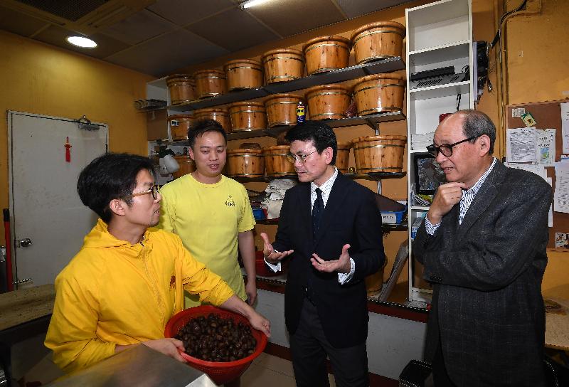 The Secretary for Commerce and Economic Development, Mr Edward Yau (second right), today (February 21) visited a shop selling dried food in Fu Shin Street and talked with the shopkeepers during his visit to Tai Po District. Looking on is the Chairman of the Tai Po District Council, Mr Cheung Hok-ming (first right).