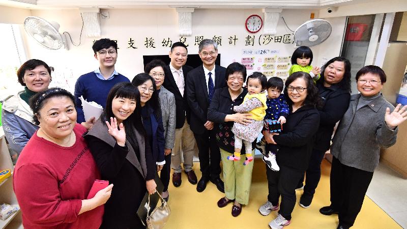 The Secretary for Labour and Welfare, Dr Law Chi-kwong, today (February 26) visited Sha Tin District and called at the Hong Kong Single Parents Association (HKSPA) Jockey Club Neighbourhood Support Centre operating the Neighbourhood Support Child Care Project under the Social Welfare Department. Photo shows Dr Law (eighth right); the Under Secretary for Labour and Welfare, Mr Caspar Tsui (ninth right); the District Social Welfare Officer (Sha Tin), Mrs Gloria Lee (10th right); and the Chief Executive of the HKSPA, Ms Jessie Yu (first right), with home-based carers and children receiving care services.