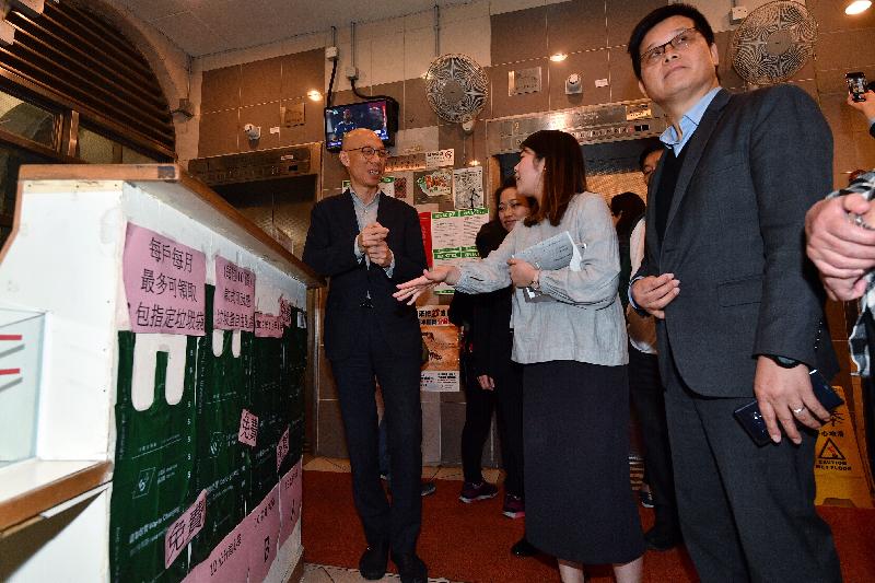 The Secretary for the Environment, Mr Wong Kam-sing, visited Ka Fuk Estate, Fanling, today (February 28) to learn more about the implementation of the municipal solid waste charging trial project. Photo shows Mr Wong (first left) being briefed on the distribution and recording process for simulated designated garbage bags at the lobby.