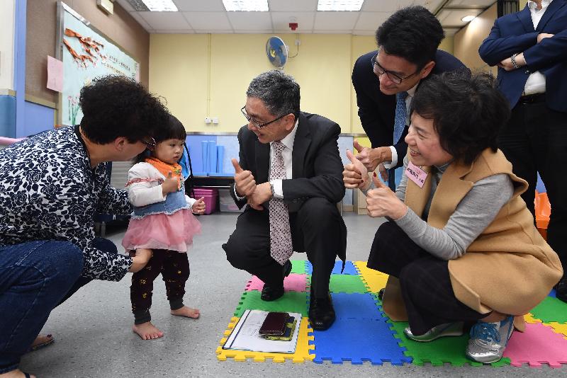 The Secretary for Financial Services and the Treasury, Mr James Lau (centre), visits the Women Service Association and speaks with a child carer and a child joining the Neighbourhood Support Child Care Project today (March 6). Accompanying him is the Under Secretary for Financial Services and the Treasury, Mr Joseph Chan (second right).