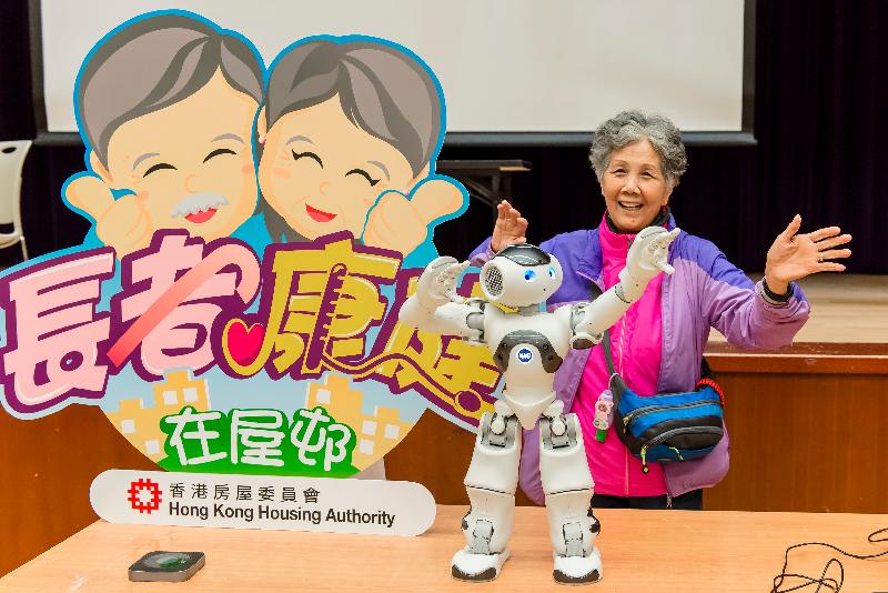 The Hong Kong Housing Authority, in collaboration with the School of Nursing of the University of Hong Kong, held a health talk under the Healthy Ageing in Public Rental Housing Estates programme in Lai Chi Kok Community Hall last month. Photo shows an AI robot and an elderly tenant at the event.