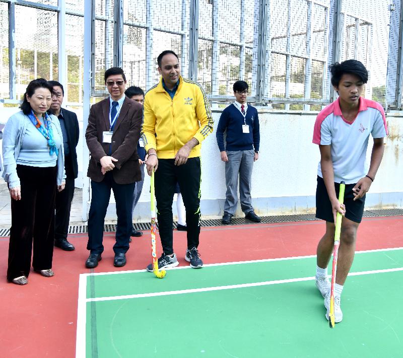 The Secretary for Justice, Ms Teresa Cheng, SC, visits Caritas Wu Cheng-chung Secondary School in Pokfulam today (March 12). Photo shows Ms Cheng (first left) watching students' hockey training session.