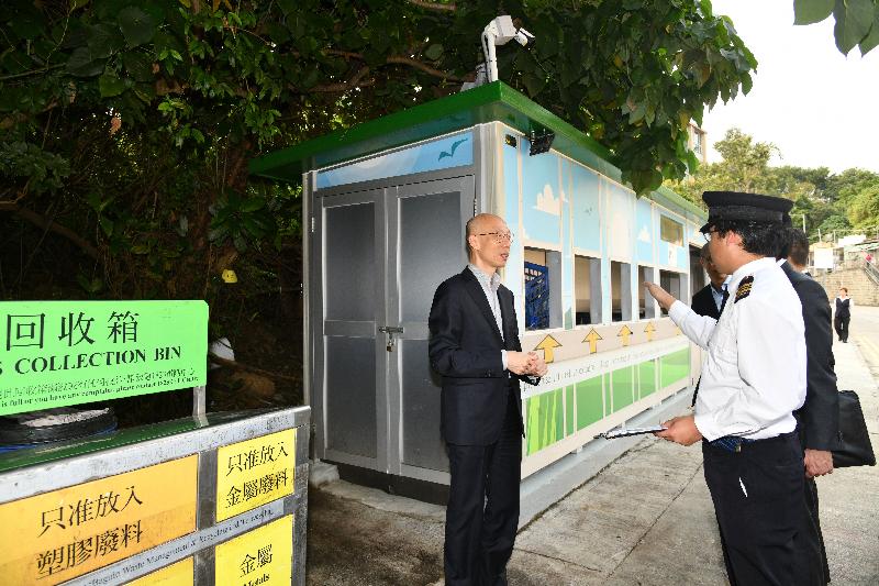 The Secretary for the Environment, Mr Wong Kam-sing, went to Ma Fung Ling Road, Yuen Long, today (March 19) to view the easy-throw aluminium refuse collection point (RCP) operated by the Food and Environmental Hygiene Department. Photo shows Mr Wong (left) being briefed on the design features and daily operation of the RCP.