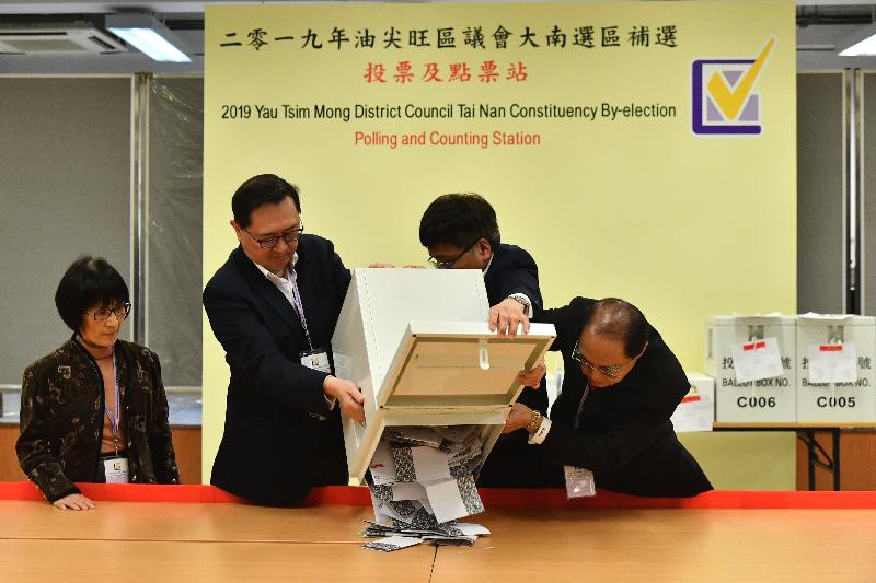 The Electoral Affairs Commission (EAC) Chairman, Mr Justice Barnabas Fung Wah (second left), emptied a ballot box at the counting station at the Fresh Fish Traders' School for the by-election in the Tai Nan Constituency of the Yau Tsim Mong District Council last night (March 24). Also present were EAC members Mr Arthur Luk, SC (first right) and Professor Fanny Cheung (first left).