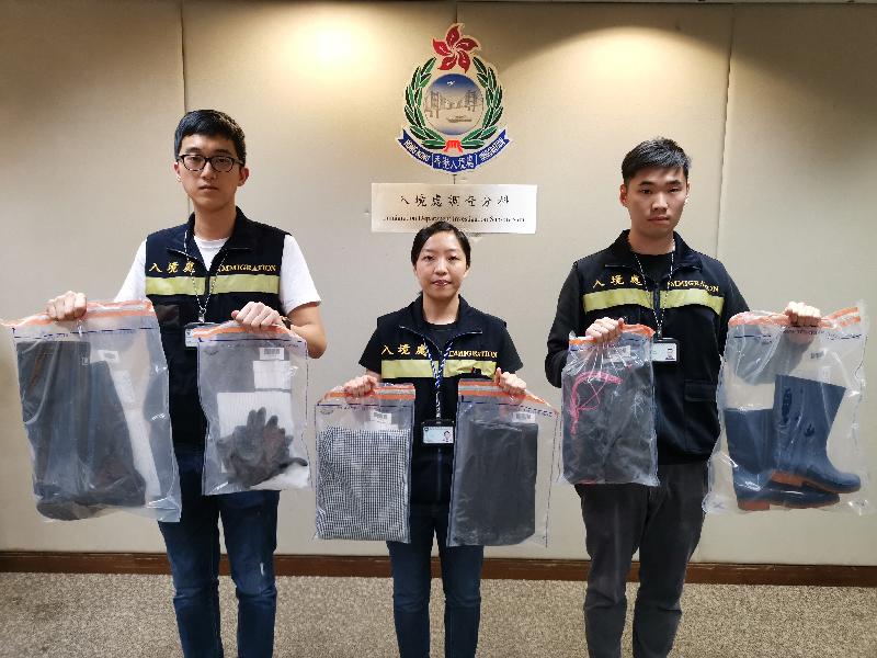 The Immigration Department mounted a territory-wide anti-illegal worker operation on March 27. Photo shows officers holding items seized during the operation.