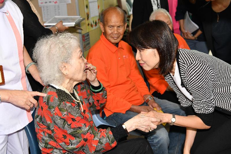 The Director of Social Welfare, Ms Carol Yip (first right), chats with a resident during her visit to a private residential care home for the elderly in To Kwa Wan today (April 9).