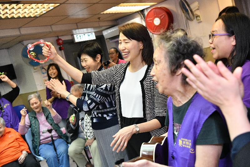 The Director of Social Welfare, Ms Carol Yip (third right), joins residents in a music session during her visit to a private residential care home for the elderly in To Kwa Wan today (April 9).