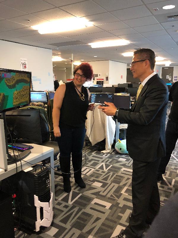 The Financial Secretary, Mr Paul Chan (right), today (April 8, US West Coast time) in Seattle plays a video game created by students of the DigiPen Institute of Technology during his visit there.