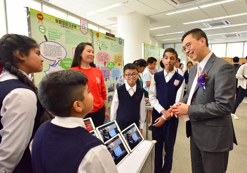 The Secretary for Education, Mr Kevin Yeung, today (April 9) officiated at the award presentation ceremony and project exhibition of the Forty Years of Reform and Opening-up Project Learning Award Scheme organised by the Education Bureau. Photo shows Mr Yeung (first right) viewing the award-winning works and chatting with students.