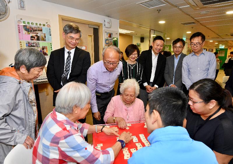 The Secretary for Labour and Welfare, Dr Law Chi-kwong, today (April 24) visited Islands District and toured the Neighbourhood Advice-Action Council (NAAC) Tung Chung Integrated Services Centre. Photo shows (from back row, sixth right) Dr Law; the Executive Director of the NAAC, Mr Tai Keen-man; the District Social Welfare Officer (Central Western, Southern and Islands), Ms Ip Siu-ming; the Under Secretary for Labour and Welfare, Mr Caspar Tsui; the District Officer (Islands), Mr Anthony Li; and the Chairman of the NAAC, Mr Tony Yen, watching elderly persons playing a board game.