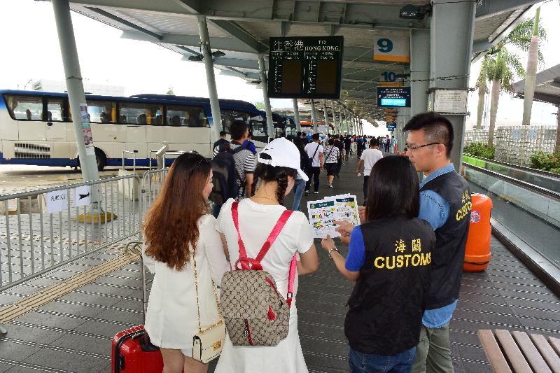 香港海關今日（四月二十九日）展開代號「子彈」的巡查行動，在「五一黃金周」期間加強保障消費者的工作。圖示海關人員在過境巴士站派發提醒訪港旅客精明消費的單張。