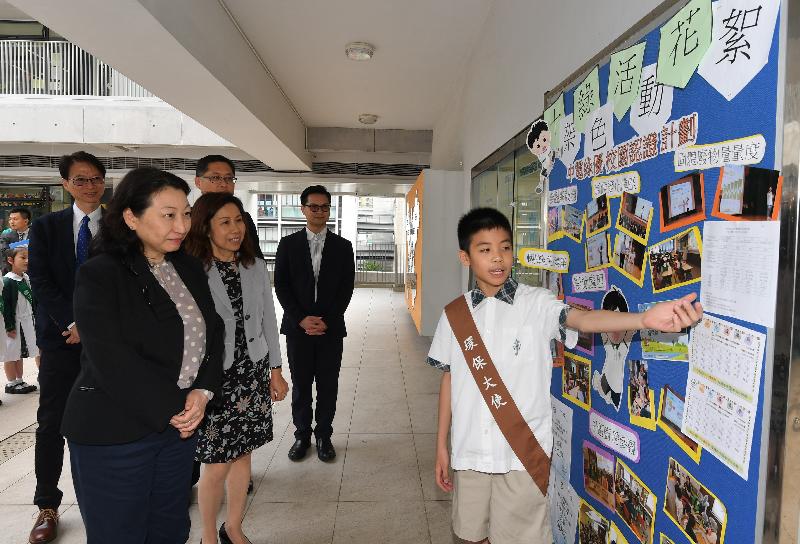 The Secretary for Justice, Ms Teresa Cheng, SC, visited SKH Holy Cross Primary School in Kowloon City today (May 3). Photo shows Ms Cheng (second left) listening to a student presentation on the school's green facilities.