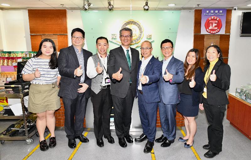 The Financial Secretary, Mr Paul Chan (fourth left), accompanied by the Chairman of the Kwai Tsing District Council, Mr Law King-shing (second left), and the District Officer (Kwai Tsing), Mr Kenneth Cheng (third right), today (May 7) visited a local food manufacturer with its own brand, where they are pictured with management and staff.