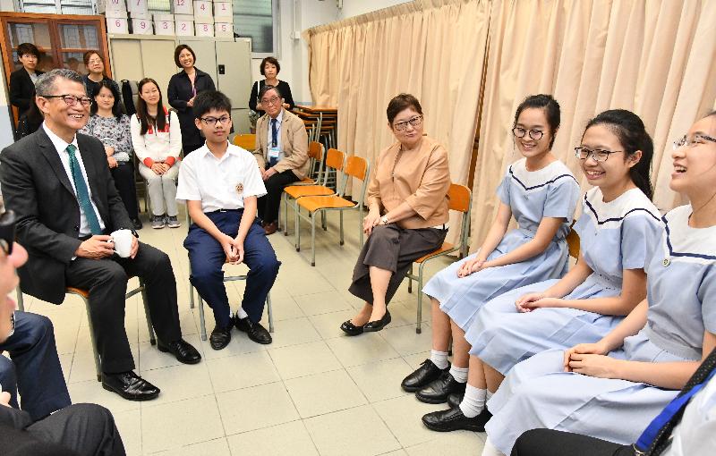 The Financial Secretary, Mr Paul Chan, today (May 7) visited SKH Lam Woo Memorial Secondary School in Kwai Tsing District. Photo shows Mr Chan (first left), accompanied by the School Supervisor, Dr Alice Yuk (fourth right), chatting with students.
